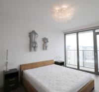 Bedroom with a bed and art, large window with a view, 3-room apartment.