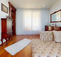 The interior of a family house with light curtains, wooden furniture, and a comfortable sofa.