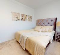 Bedroom with a comfortable bed, tasteful decorations, and a lamp in a family house.