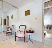 Hallway in a family house with mirrored doors, an armchair, and a side table.