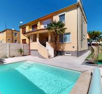 A family house in Komárno with a swimming pool, a lounger, and a garden swing in the yard.