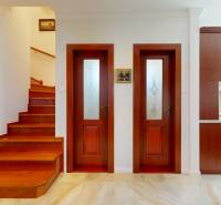 Staircase, doors, and kitchen inside a family house with wooden elements.