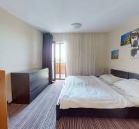 Bright bedroom in a two-room apartment with a large bed, wardrobe, and decoration.