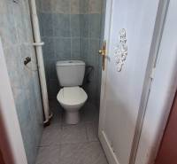 A bathroom tiled in a 3-room apartment with closed doors.