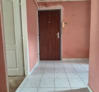 Entrance hallway with light-colored tiles and pink walls in a 3-room apartment.