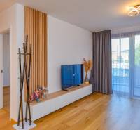 Living room in a 3-room apartment with a TV, glassed-in balcony, and wooden floor.