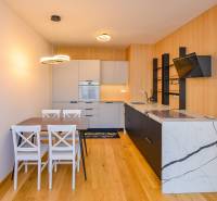 Kitchen in a 3-room apartment, wooden floor, dining table for four people.