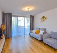 Living room with a comfortable sofa, wooden floor, and a television in a 3-room apartment.