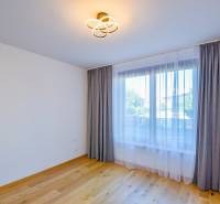 An unfurnished room with wooden flooring and curtains in a 3-room apartment.