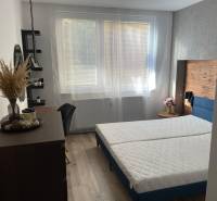 A bright bedroom in a 3-room apartment with a bed and wooden details.