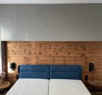 A bright bedroom in a 3-room apartment with a wooden headboard and a blue bed.