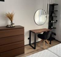 Bedroom with a dresser, mirror, and desk in a 3-room apartment.
