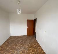 Empty room in a 3-room apartment with light walls and parquet flooring.