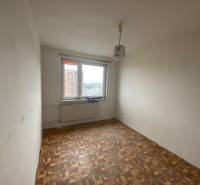 A room in a 3-room apartment with a wooden floor and a window with a view.