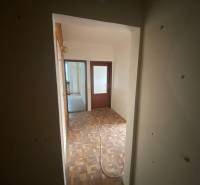 A hallway in a 3-room apartment with wooden flooring and two rooms.