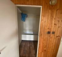 Bathroom in a 3-room apartment with wooden paneling and a bathtub.