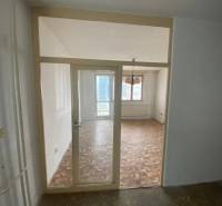 Interior of a 3-room apartment with parquet flooring and a large window.