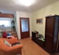 Living room in a family house with wooden furniture and a staircase.