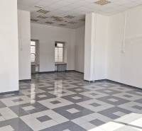 Spacious commercial spaces with tiled floors and high ceilings.