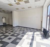 Commercial spaces with large windows, tiles, and white walls.