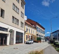 Commercial premises on Konventná Street in Bratislava - Old Town with cars and pedestrians.