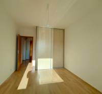 A room in a 3-room apartment with a wooden decor floor and a built-in wardrobe.