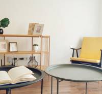 Interior of a 2-room apartment with decorative elements, a chair, and a table with a book.