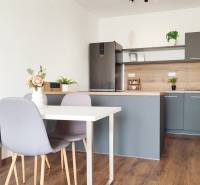 Kitchen with dining table and chairs, 2-room apartment with wooden flooring and decoration.
