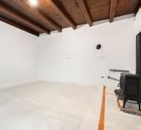 A white interior with a wooden ceiling and a stove in a family house.