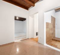The interior of a family house with a wooden ceiling and adjoining rooms with tiles.
