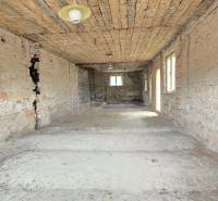 Unfinished interior of a family house with exposed brick walls and floor.