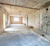 The interior of a family house with brick walls and an unfinished ceiling, ready for renovation.