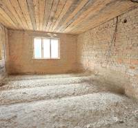 Unplastered brick walls in a family house, ongoing renovation, natural light from windows.