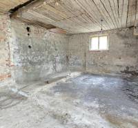 An inadequate interior of a family house with bare brick and plaster walls.