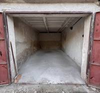 An open garage on Považská Street in Košice, in the Západ district, with a concrete floor.
