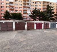 Garages on Považská Street in Košice - West district, with a panel building in the background.