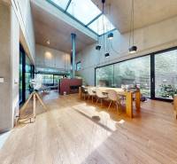 Interior of a family house with wooden flooring and glass windows letting in light.