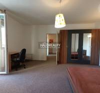 The interior contains a table, a chair, a wardrobe, and a bed in a studio apartment.