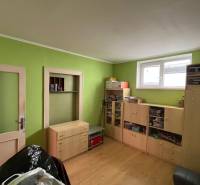 A room in a family house with wooden furniture and green walls.