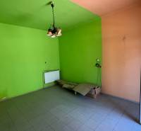The interior of a family house with colorful walls, tiled floor, and a pendant light.
