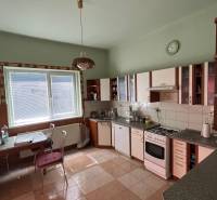 A kitchen in a family house with a dining table and kitchen unit.