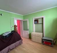 A room in a family house with wooden furniture and green walls.