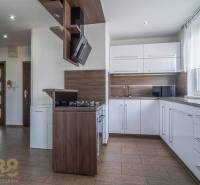 A kitchen in a 3-room apartment with white cabinets and wooden accessories.