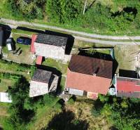 Family houses in Horné Hámre with surrounding gardens and access road, aerial view.