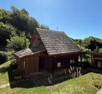 A wooden family house in Horné Hámre, surrounded by greenery and a blue sky.