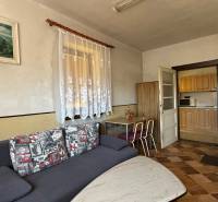 Interior of a family house with a sofa, table, and kitchen.