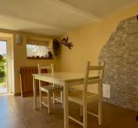 Interior of a family house with a dining table, open entrance to the garden.