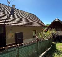 A family house in Horné Hámre with a wooden gate and flowers in the yard.