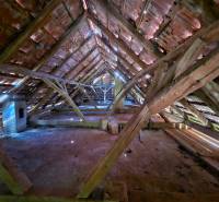 The attic of a family house with wooden beams and a preserved brick roofing system.