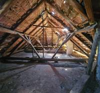 Attic with wooden structure and roof tiles in a family house.